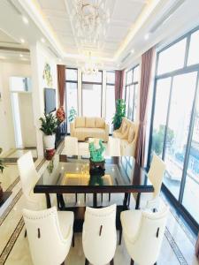 un salon avec une table et des chaises blanches dans l'établissement Villa FLC 7 Ngủ Hạ Long - Đẳng cấp - Phòng Karaoke riêng, à Hạ Long