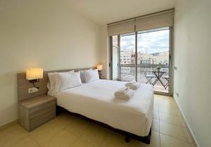 a bedroom with a large bed and a large window at Stay U-nique Apartments Pau Claris in Barcelona