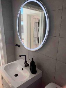 uma casa de banho com um lavatório branco e um espelho. em Sea side villa with breathtaking view em Gotemburgo