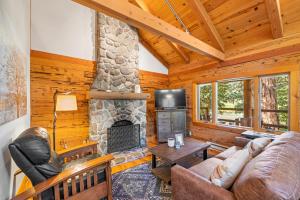 uma sala de estar com uma lareira de pedra num chalé de madeira em River Cabins | The Lost Sierra Ranch em Graeagle