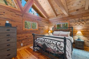 um quarto com uma cama num chalé de madeira em River Cabins | The Lost Sierra Ranch em Graeagle