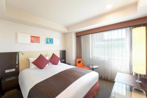 a hotel room with a bed and a large window at Hotel JAL City Kannai Yokohama in Yokohama