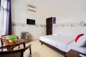 胡志明市的住宿－Hoa Hồng Hotel Ho Chi Minh City，一间卧室配有一张床、一张桌子和一台电视。