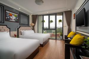a hotel room with two beds and a television at Bella Premier Hotel & Rooftop Skybar in Hanoi
