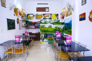 a dining room with black tables and chairs at Highrange Plaza in Thekkady