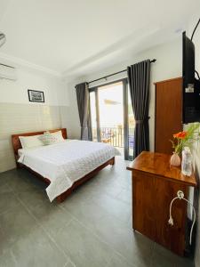 una camera con un letto e una televisione di Cuong Thinh Homestay a Hoi An