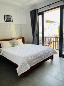 una camera con un letto e una grande finestra di Cuong Thinh Homestay a Hoi An