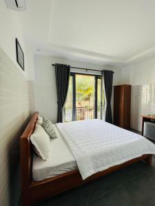 Schlafzimmer mit einem großen Bett und einem Fenster in der Unterkunft Cuong Thinh Homestay in Hoi An