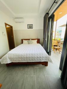 ein Schlafzimmer mit einem Bett und einem Balkon in der Unterkunft Cuong Thinh Homestay in Hoi An
