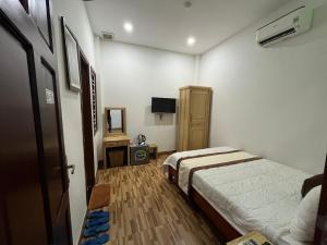 Cette chambre comprend deux lits et une télévision. dans l'établissement Cát Tâm Hotel, à Quy Nhơn