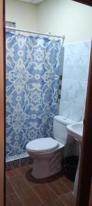 a bathroom with a toilet and a shower curtain at Casa Villa Flores in San Martín Zapotitlán