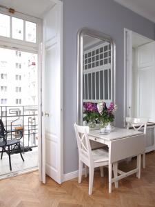 a white dining room with a table and a mirror at Warsaw Concept in Warsaw