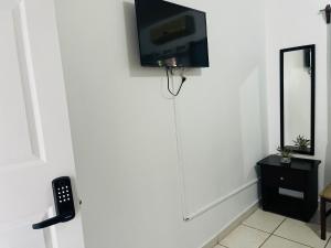 WE Hotel Apartments في La Lima: غرفة مع تلفزيون بشاشة مسطحة على الحائط