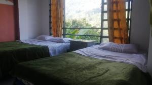 twee bedden in een kamer met een raam bij Apartamento hermosa vista in Líbano