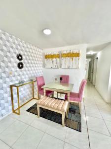 a dining room with a table and pink chairs at Increible apartamento en vup in Valledupar