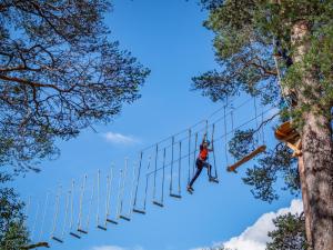 a man on a zip line between two trees at Krokstrand Fjellpark AS in Storforshei