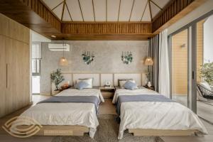 a bedroom with three beds in a room at LUX VILLA THE TROPICANA NOVAWORLD HỒ TRÀM in Ấp Thanh Bình