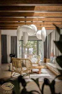 a living room with chairs and a table and chandeliers at LUX VILLA THE TROPICANA NOVAWORLD HỒ TRÀM in Ấp Thanh Bình