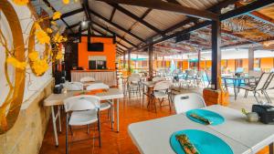 un restaurante con mesas blancas y sillas blancas en Hotel La Hacienda, en Quesada