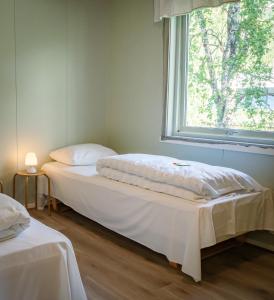 two beds in a room with a window at Krokstrand Fjellpark AS in Storforshei