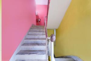 una escalera con paredes rosas y amarillas en SPOT ON Sri Jagannath Nibas, en Puri