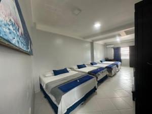 uma fila de quatro camas num quarto em Hotel Cristo rey em Tabatinga