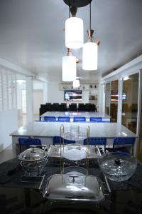 a kitchen with a table with plates and bowls on it at GRIN MCFLY INTERNATIONAL BEACHFRONT GUEST HOUSE in Fuerte