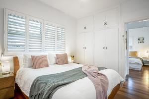 a bedroom with white walls and a bed with pillows at 1-29 Beech Street in Evans Head