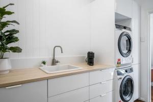 a white kitchen with a sink and a washing machine at 1-29 Beech Street in Evans Head