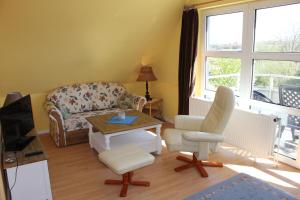 ein Wohnzimmer mit einem Sofa, einem Tisch und Stühlen in der Unterkunft Apartmenthaus Padua in Büsum