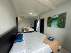 2 camas en un dormitorio pequeño con una pintura en la pared en Hotel Cristo rey, en Tabatinga