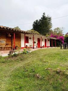 uma casa com paredes vermelhas e brancas e um quintal em Casa Finca Las Chispas em Medellín