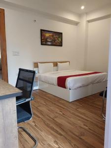 a bedroom with a bed and a desk and a chair at Hotel BSH Group in Noida