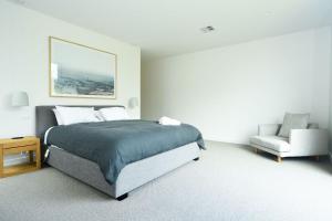 een slaapkamer met een bed en een stoel bij Elske on St Anns in Flinders