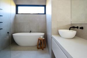 een badkamer met een wit bad en een wastafel bij Elske on St Anns in Flinders +24 foto's