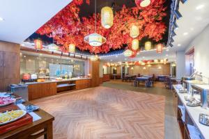 深セン市にあるTrue Go Hotel - Shenzhen Futian Huaqiang Northのテーブルと椅子が備わる広い部屋を提供するレストラン