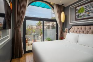 ein Schlafzimmer mit einem Bett und einem großen Fenster in der Unterkunft Bella Premier Hotel & Rooftop Skybar in Hanoi