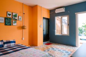 a bedroom with orange and blue walls and a bed at Ruby Homestay Phú Yên in Tuy Hoa