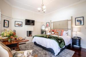 1 dormitorio con cama, mesa y escritorio en Rosemont House Luxury BnB, en Noojee