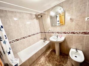 La salle de bains est pourvue d'un lavabo, d'une baignoire et de toilettes. dans l'établissement Vao Hol Rental - Santiago de La Ribera, à San Javier