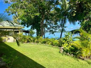 a garden with grass and trees and the water at Lapita Beach Aore Island Vanuatu in Luganville