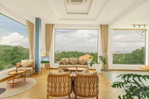 a living room with a couch and chairs and a large window at Tom Hill Boutique Resort & Spa in Phu Quoc