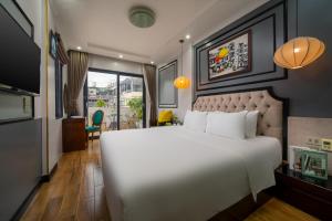 a bedroom with a large white bed and a living room at Bella Premier Hotel & Rooftop Skybar in Hanoi