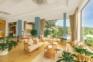 a living room with furniture and a large window at Tom Hill Boutique Resort & Spa in Phu Quoc