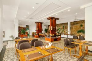 富國的住宿－Tom Hill Boutique Resort & Spa，一间设有木桌和椅子的餐厅