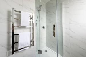 a bathroom with a shower with a glass door at Brand New 3Bedroom Retreat in South Auckland in Takanini