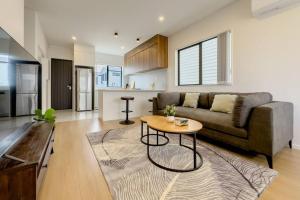 a living room with a couch and a table at Brand New 3Bedroom Retreat in South Auckland in Takanini