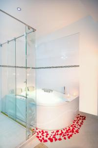 a bathroom with a tub and a glass shower at Hotel Puerto Bahia in San Gil