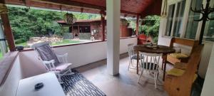 a screened in porch with a table and chairs at OLD SHEPHERD Guest House in Râșca