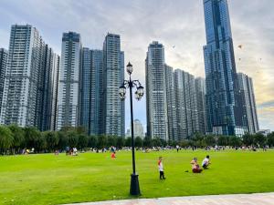 a group of people in a park with tall buildings at Landmark 81 President Suite - Vinhome Central Park in Ho Chi Minh City